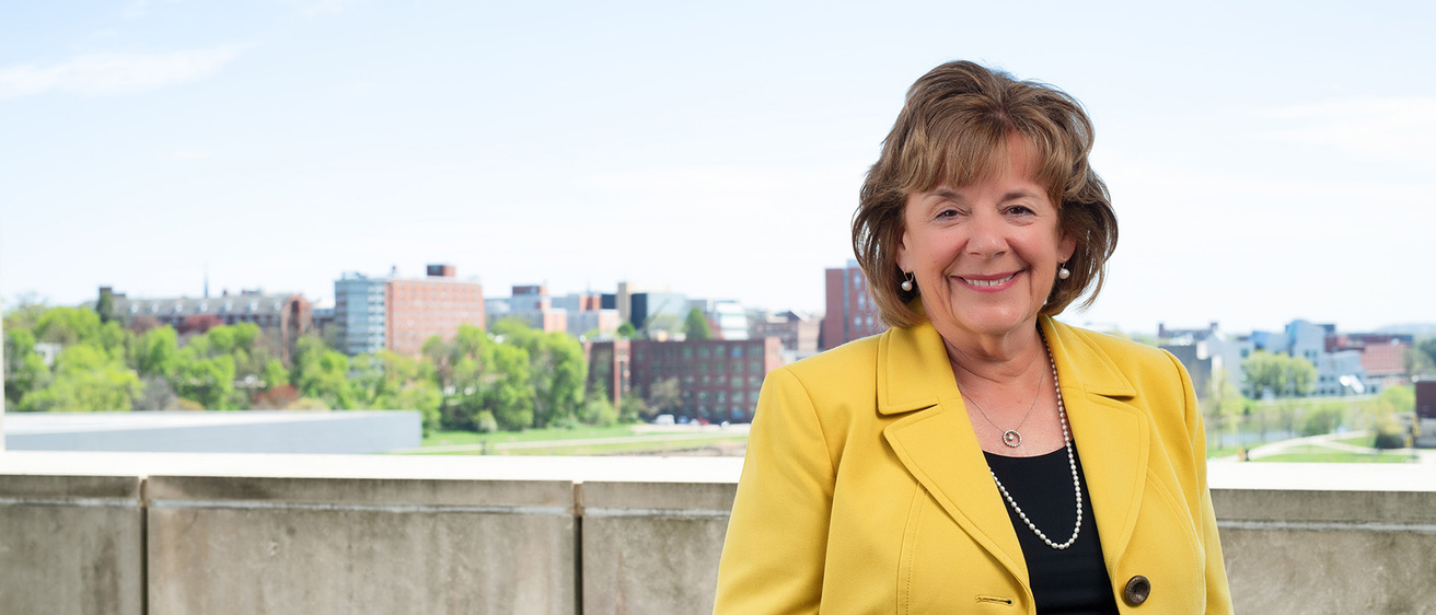 Barbara Wilson standing on a balcony on the University of Iowa campus