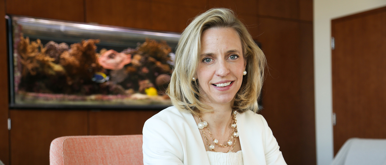 A woman sitting smiling at a desk