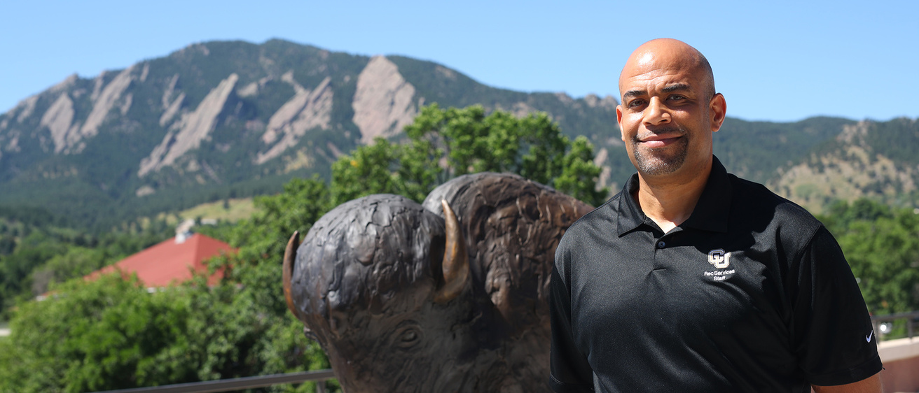 A man standing in front of a statue of a buffalo