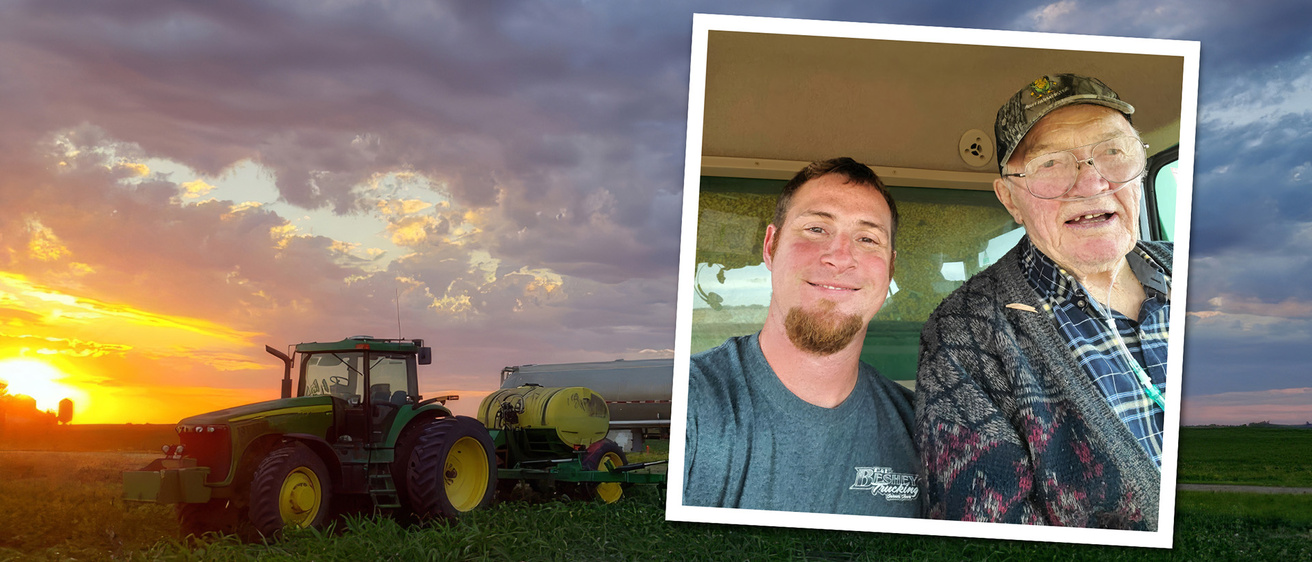 a selfie of two men is set within a shot of a tractor in a field, with the sun low in the sky