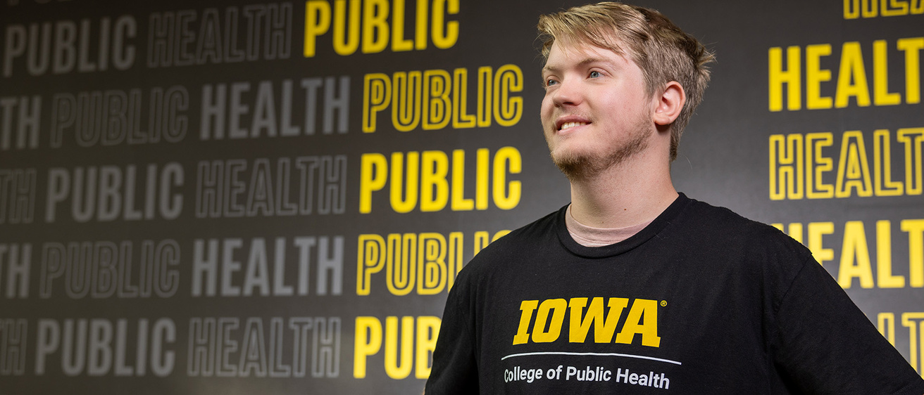 a young man standing in front of a wall that has the words "public health" repeated