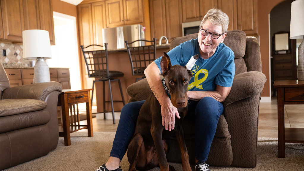 a woman sits in her living room with her Doberman puppy