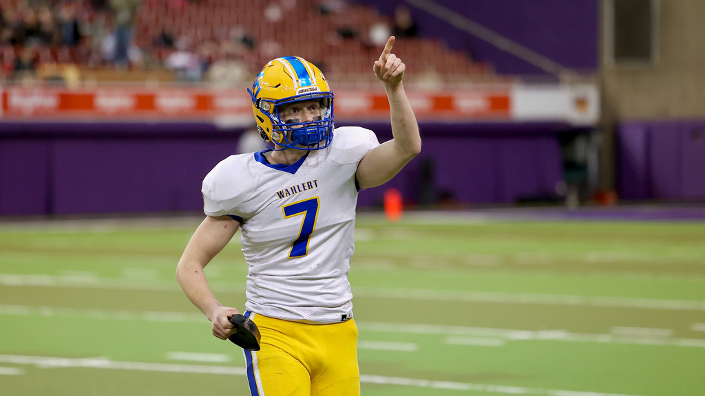 a high school football player pointing toward fans in the seating area