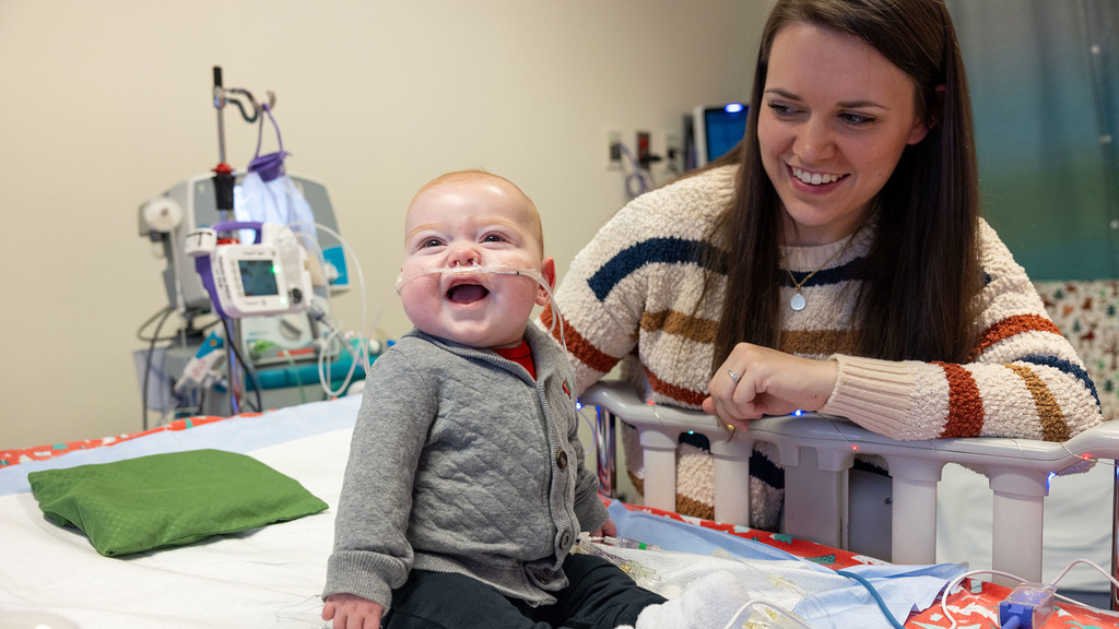 a smiling baby and his mother in a health care setting