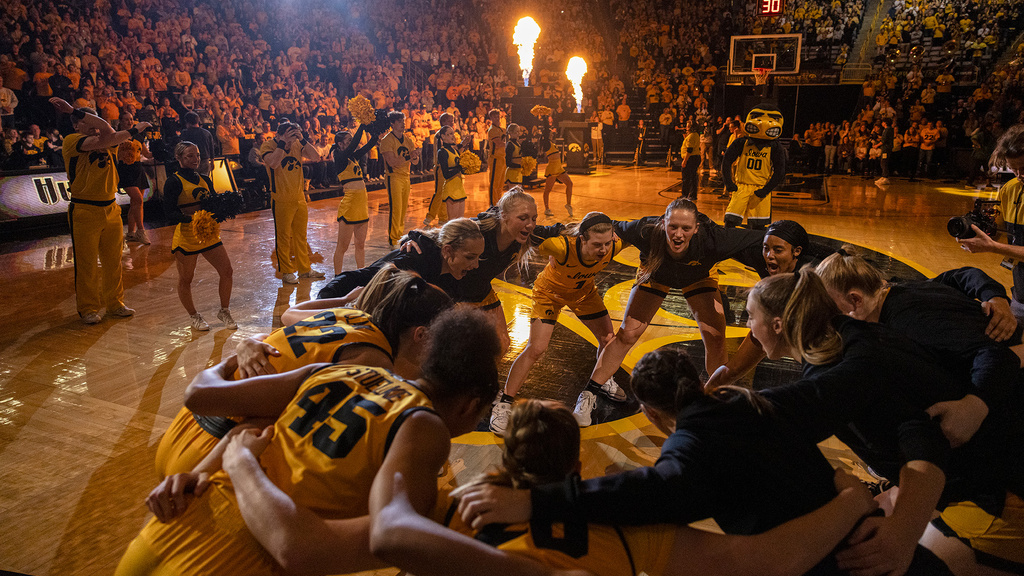 the iowa women's basketball team huddles up at center court at the end of fiery pregame festivities