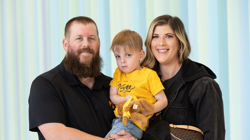 parents smiling while holding their young child