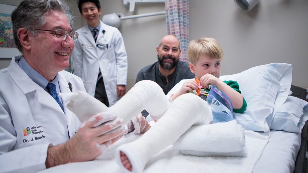 a doctor works with the casts of a young patient with clubfoot