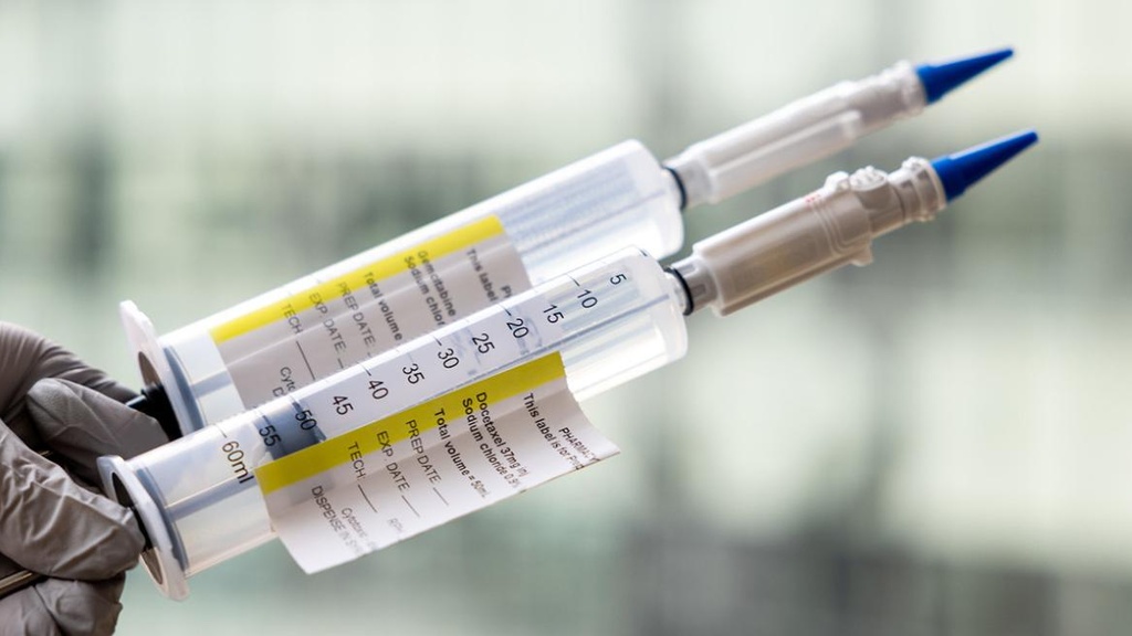 Two syringes being held up