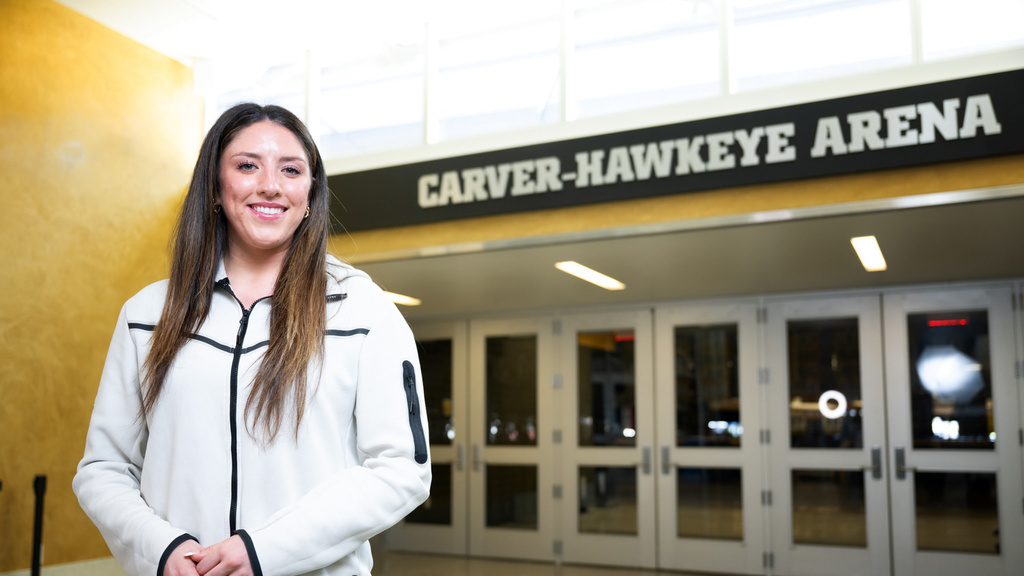 A woman smiling while standing outside of a basketball arena