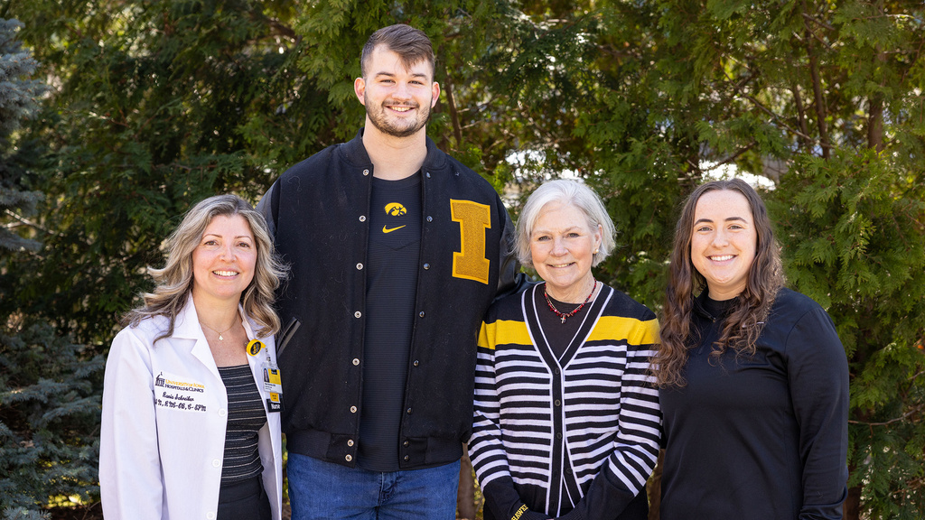 A group of four hawkeyes standing together smiling