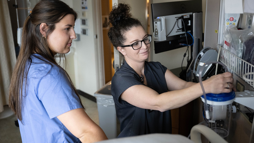 A nurse demonstrates job to student employee