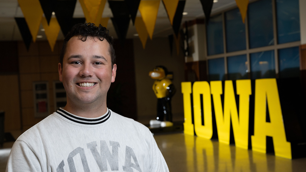A man standing in front of a Herky statue smiling