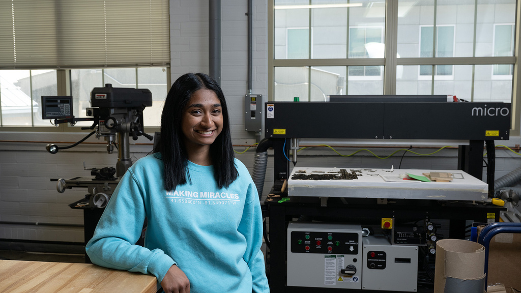 A woman standing in a workshop smiling