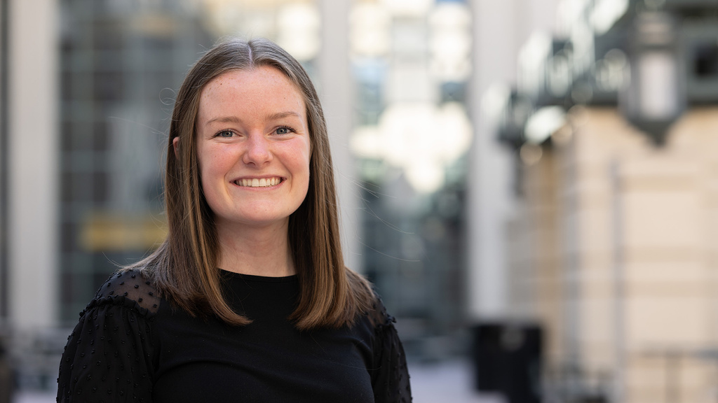 A woman smiling with a city background