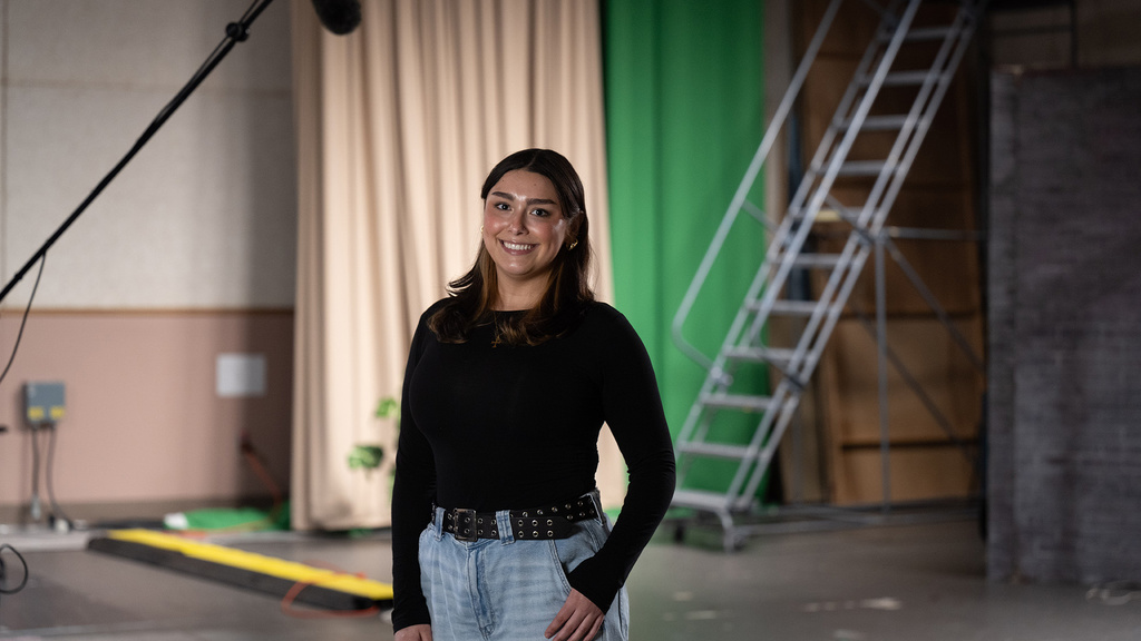 A woman standing in a studio smiling