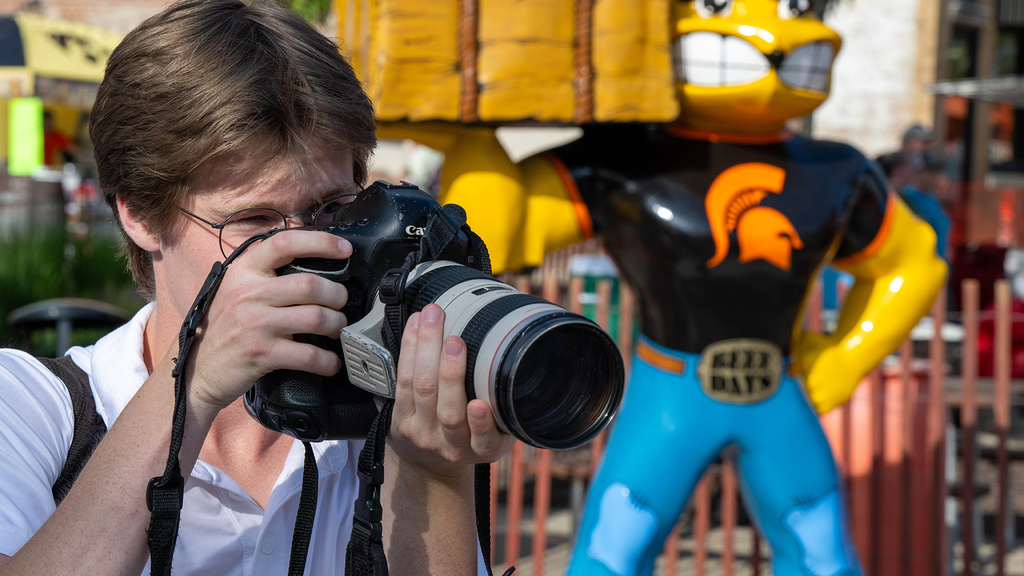 A person standing with a camera up to their face