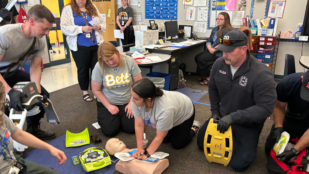 A woman performing CPR on a dummy