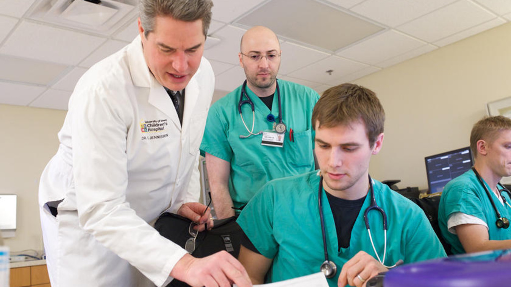 A doctor helping some co-workers with papers