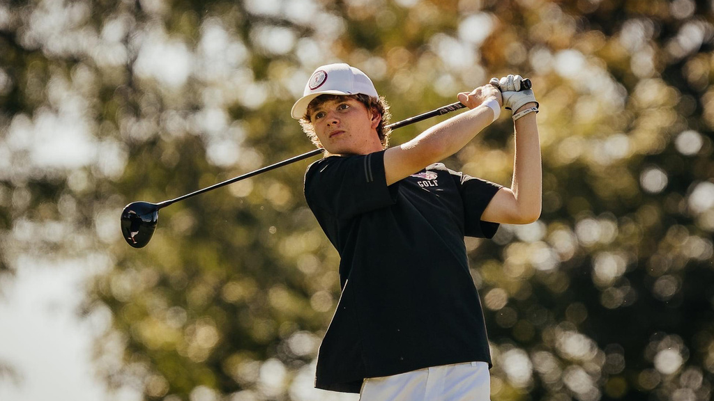 A boy swinging a golf club