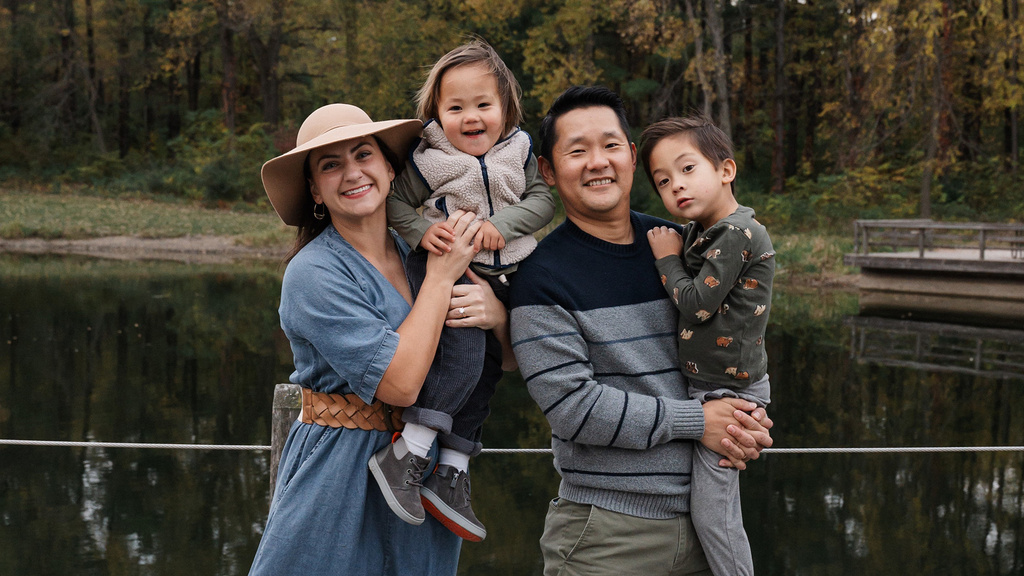 A family standing together near a lake