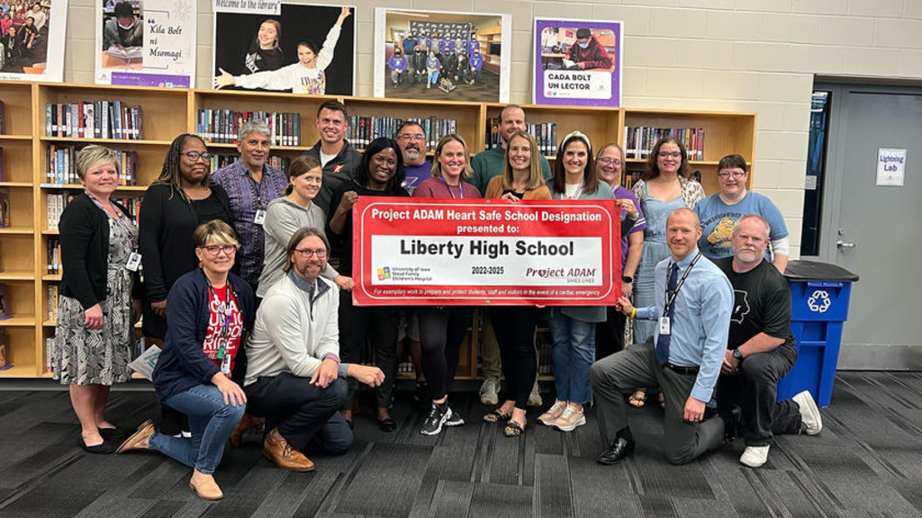 Staff members standing in a library with a banner