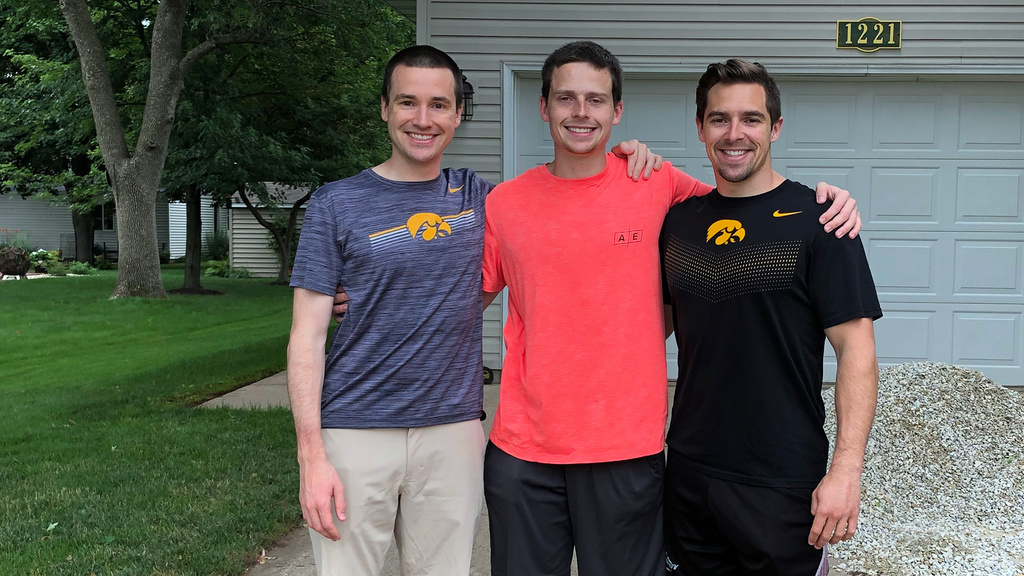 Three men standing together outside