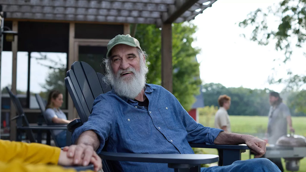 A man sitting in a chair smiling and holding someone's hand