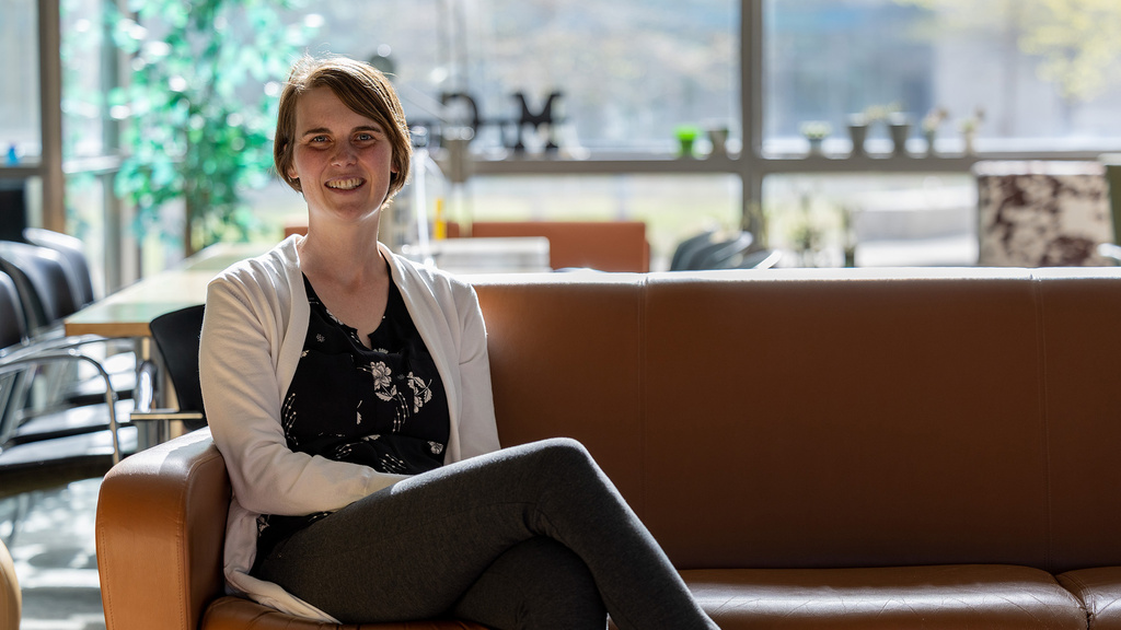 A woman sitting on a couch and smiling