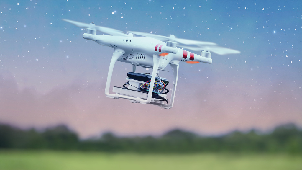 a drone flying amid a star-filled sky in a grassy and wooded landscape