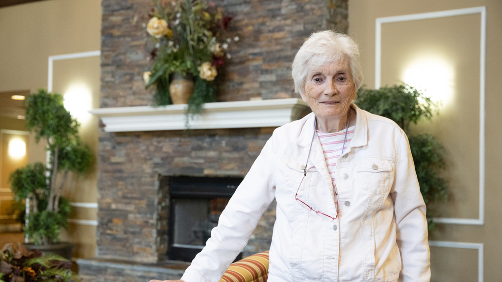 a woman standing near a fireplace