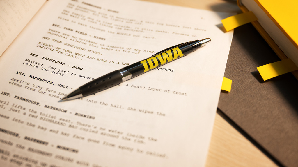 a pen with the Iowa logo rests on a screenplay
