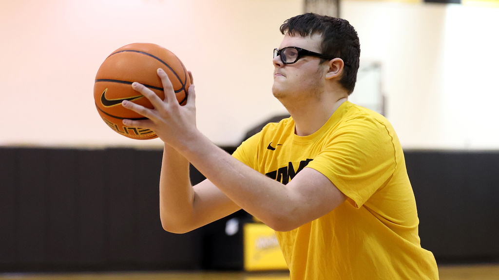 a young man shooting a basketball