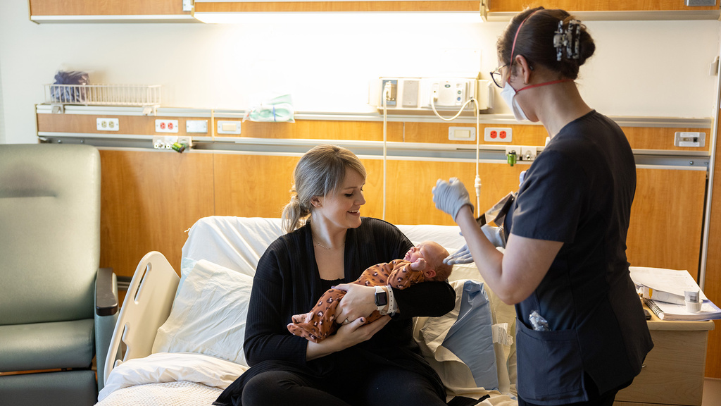 a mother and child and a health care professional in a hospital setting