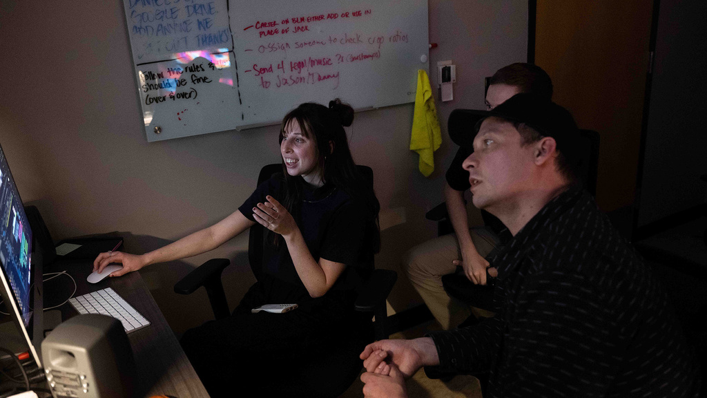 a group of people sitting behind a computer