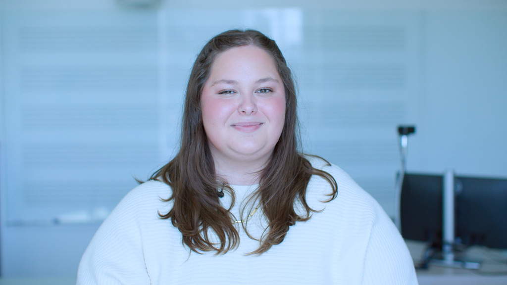 A woman standing in front of a whiteboard while smiling
