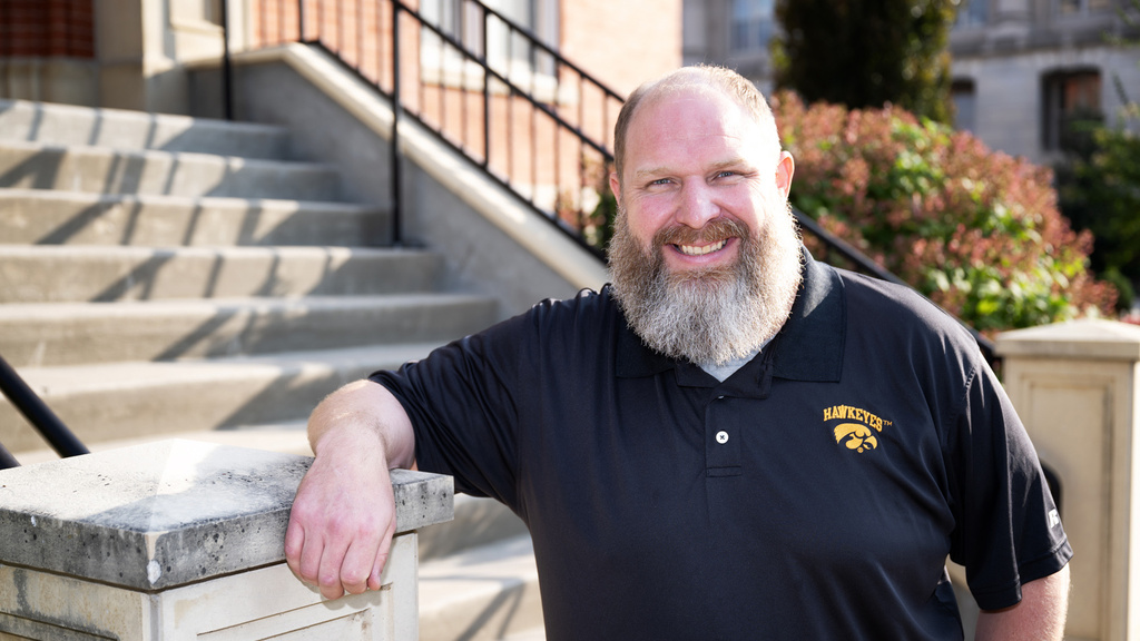 A man leaning on a set of stairs post