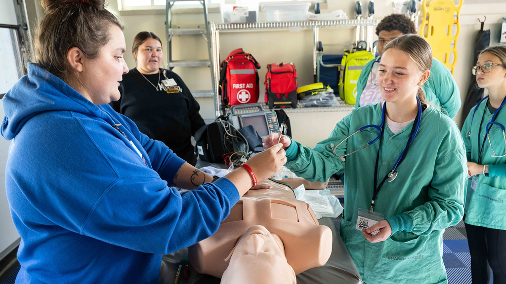 A group of people practicing on a dummy