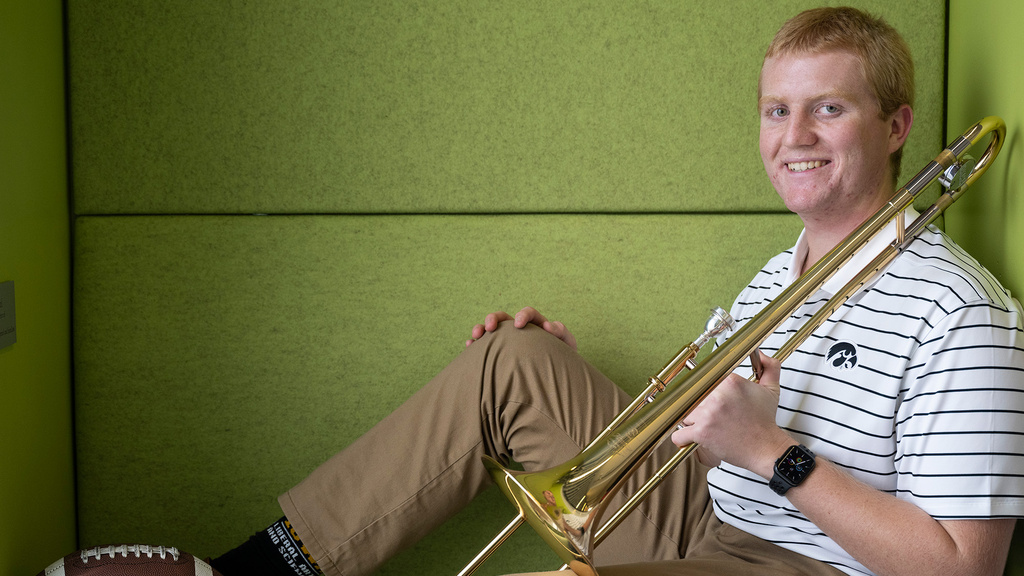 A man sitting in a booth with a basketball and trombone