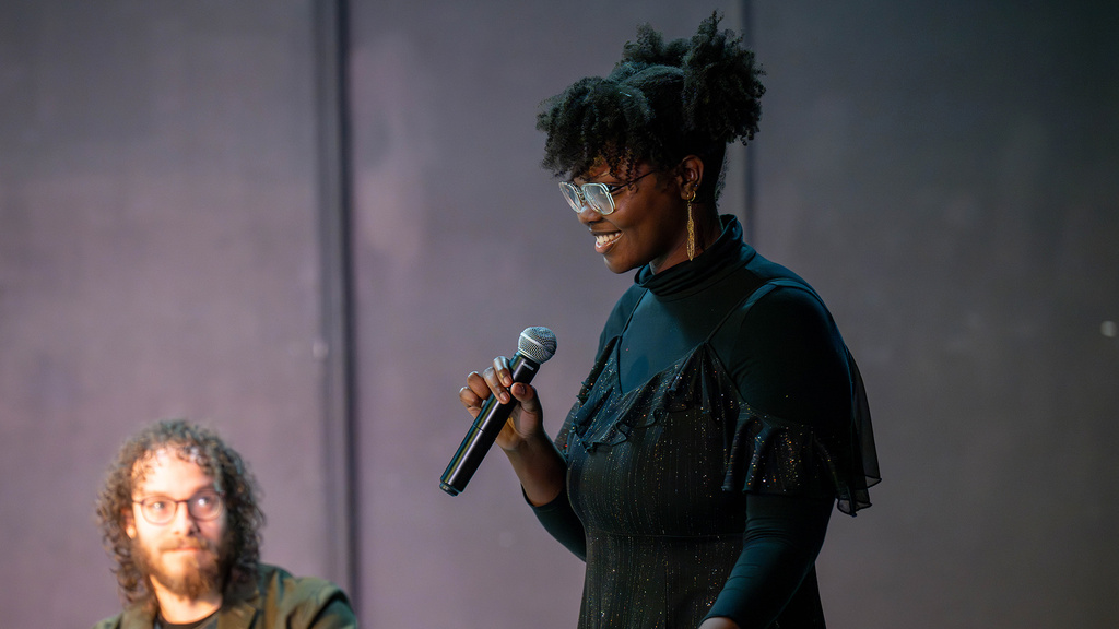 playwright Cianon Jones holds a microphone during a public staged reading of her play