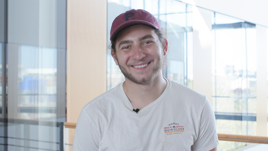 A man standing in front of a window and smiling