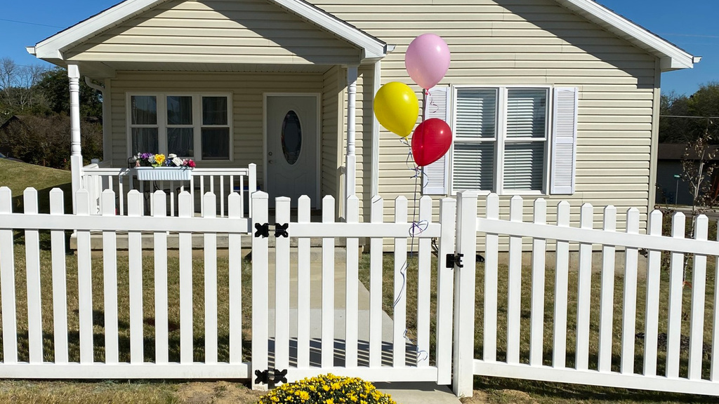a new house with balloons attached to the front gate