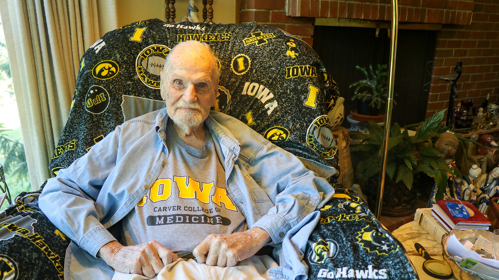 A man sitting in an Iowa themed chair