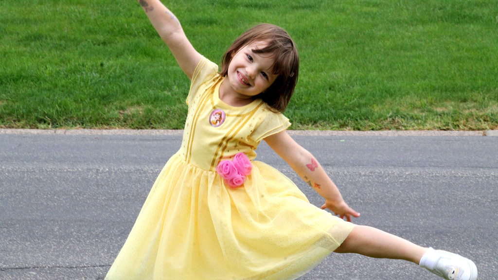 A young girl dancing in a princess dress