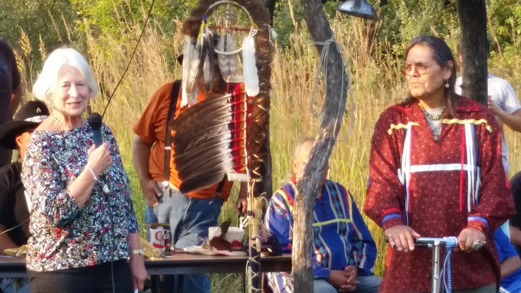 A woman with a microphone talking to a group of people
