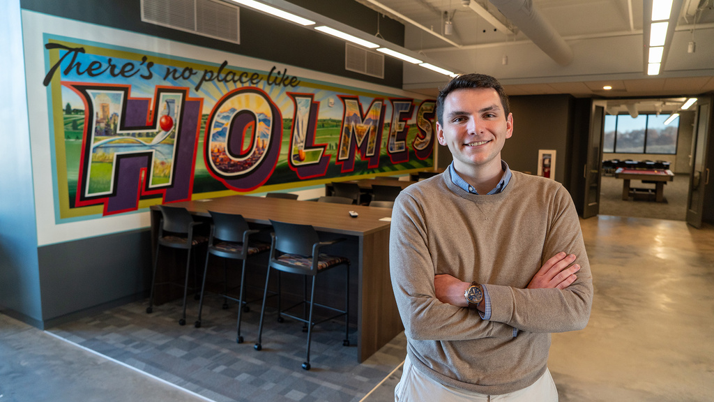 A man standing in an office and smiling