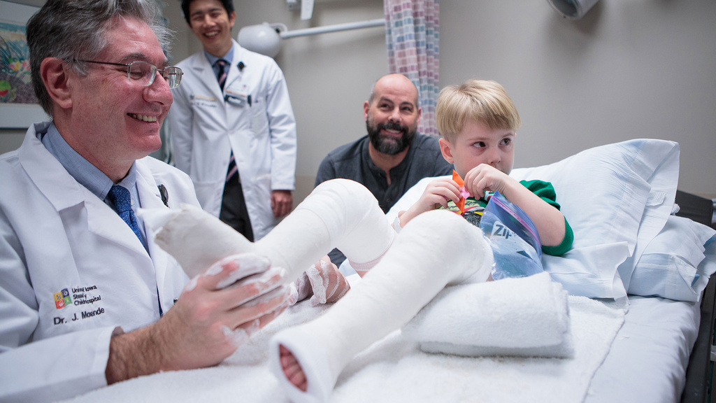 a doctor working with a young patient that has clubfoot