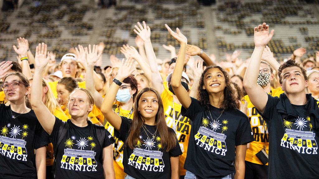 students at kinnick stadium waving to the children's hospital