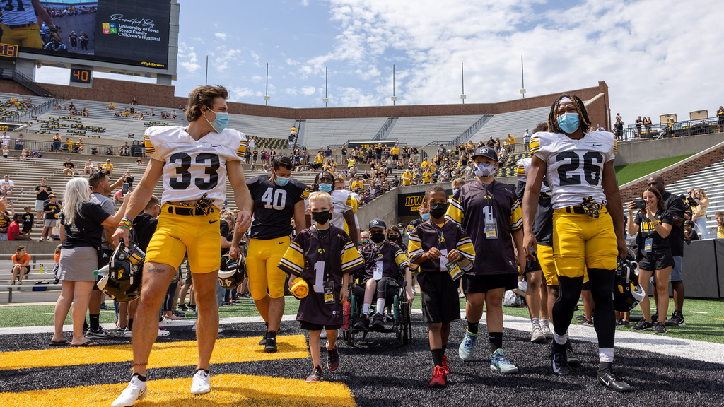 A group of kids walking out on a football field