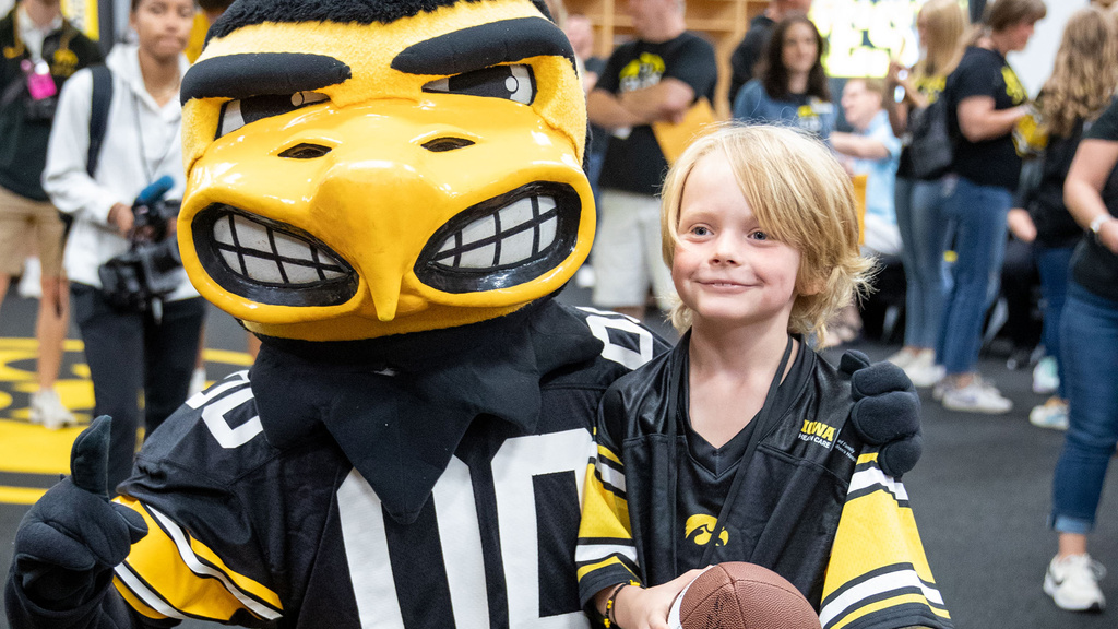 A boy taking a picture with Herky