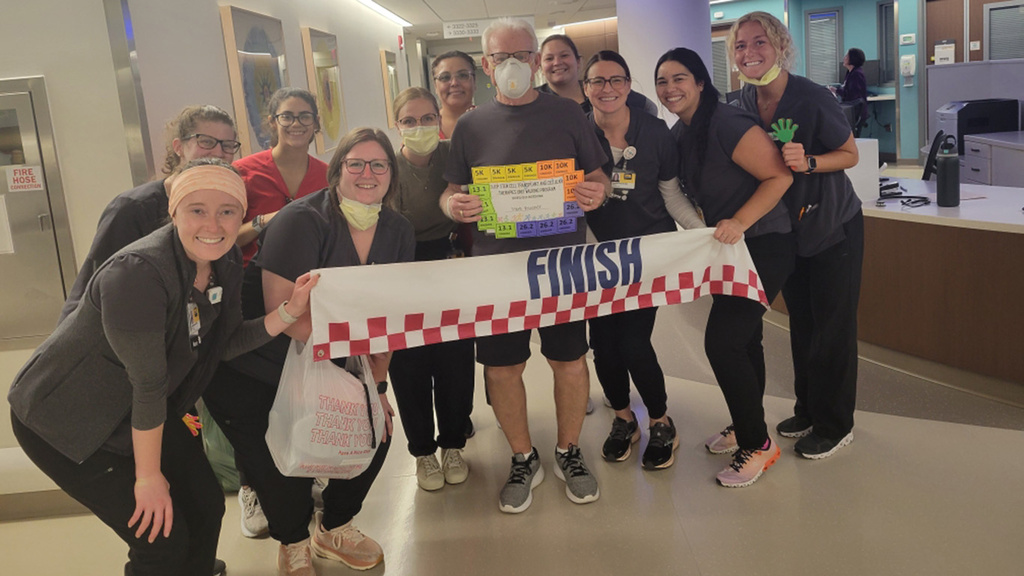 a patient surrounded by nurses after finishing a walking program